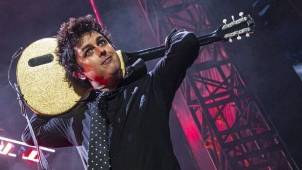 Billie Joe Armstrong plays guitar during a concert under colorful lights, HD Desktop Wallpaper