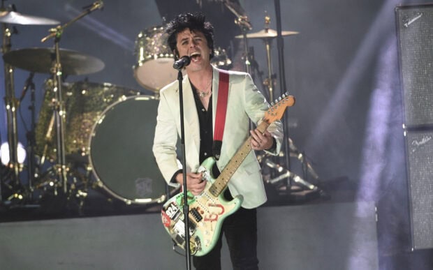Billie Joe Armstrong is playing guitar and singing passionately during a concert, 2K Desktop Wallpaper