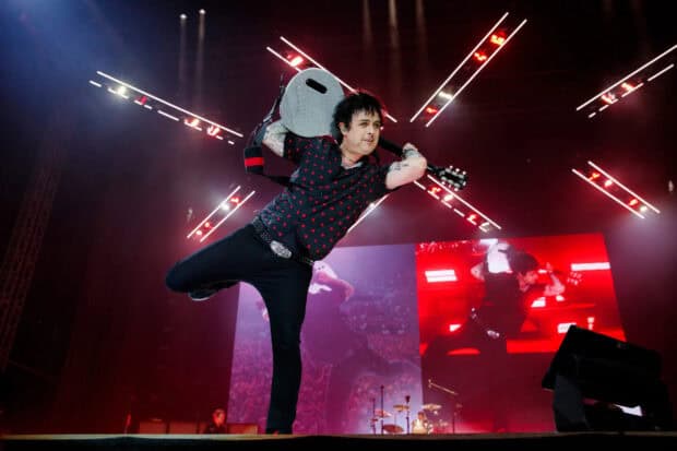 Billie Joe Armstrong is playing guitar during a concert performance with colorful lights, HD Desktop Wallpaper