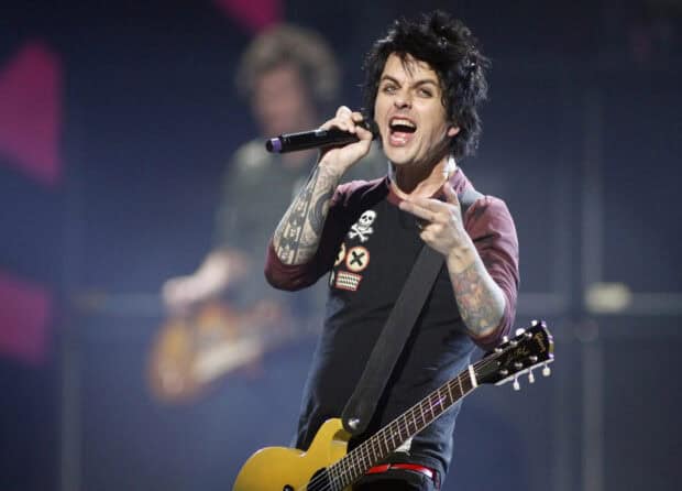 Billie Joe Armstrong is singing passionately and playing guitar during a concert, 2K Desktop Wallpaper