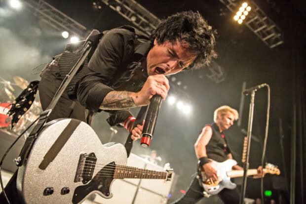 Billie Joe Armstrong passionately sings into a microphone during a live concert performance, 2K Desktop Wallpaper