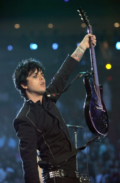 Billie Joe Armstrong raising his guitar during a live performance on stage, 2K Mobile Wallpaper