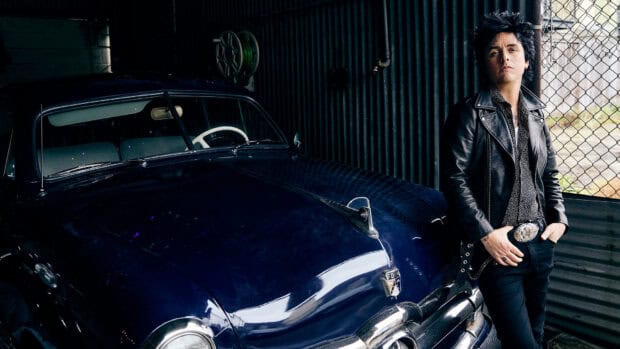 Billie Joe Armstrong stands beside a vintage car wearing a leather jacket, HD Desktop Wallpaper