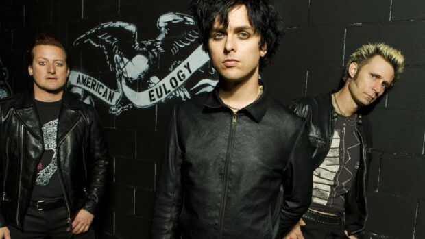 Billie Joe Armstrong stands with band members in black outfits near a wall, 2K Desktop Wallpaper