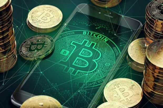 A smartphone displaying a glowing bitcoin symbol surrounded by stacked golden bitcoins, HD Mobile Wallpaper