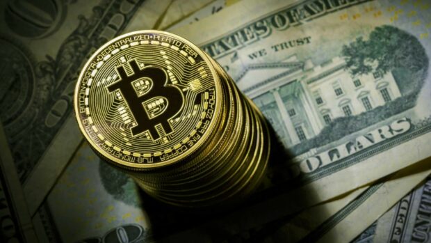 A stack of Bitcoin coins placed on top of US dollar bills, HD Desktop Wallpaper