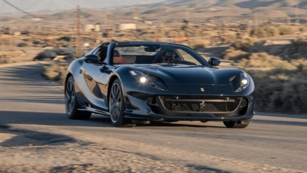 A black Ferrari 812 Gts is driving fast on a desert road with a scenic background, HD Desktop Wallpaper
