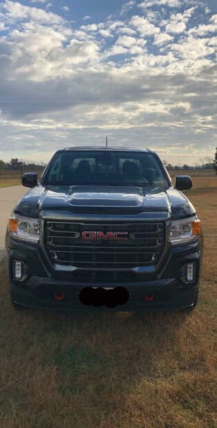 A black GMC Sierra truck is parked on grass with a cloudy sky in the background, HD Mobile Wallpaper