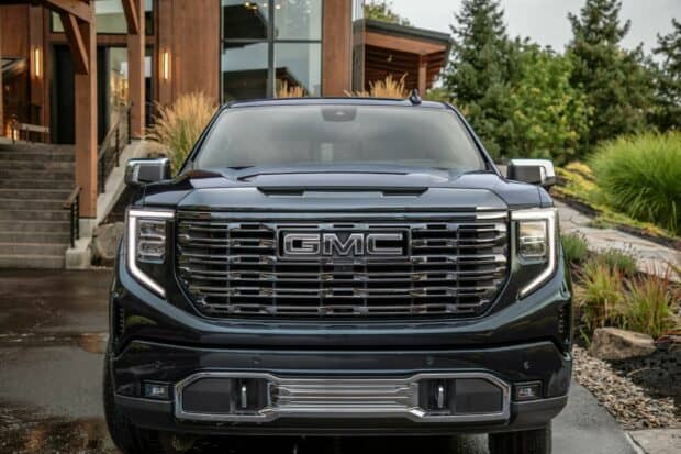 A black GMC Sierra truck is parked near a wooden house, HD Desktop Wallpaper