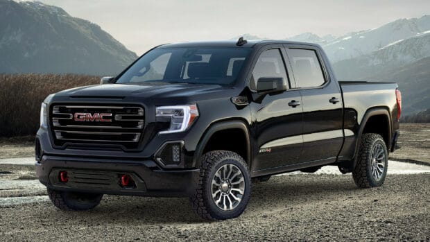 A black GMC Sierra truck is parked on a gravel area with mountains in the background, HD Desktop Wallpaper