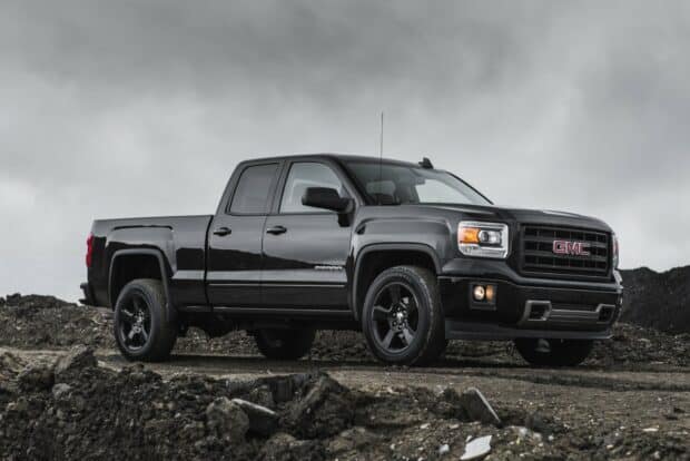 A black GMC Sierra truck is parked on a rough dirt road under a cloudy sky, HD Desktop Wallpaper