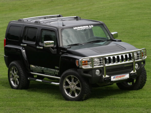 A black Hummer H3 stands on a grassy field with shiny chrome details and rugged tires, HD Desktop Wallpaper