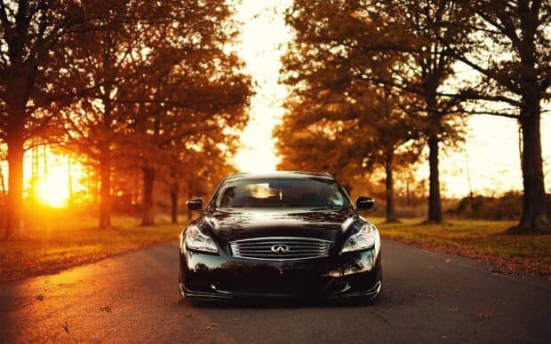 A black Infiniti G37 is parked on a tree lined road during golden hour in autumn, HD Desktop Wallpaper