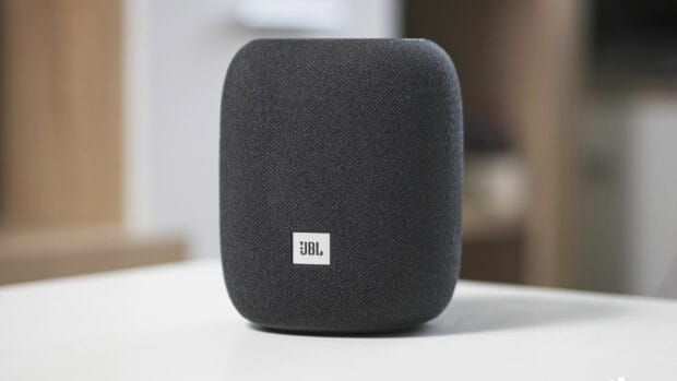 A black JBL speaker sits on a white surface in a modern room, HD Desktop Wallpaper