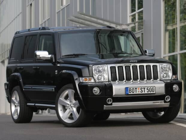 A black Jeep Commander is shown parked on the street in front of a contemporary glass building, HD Desktop Wallpaper