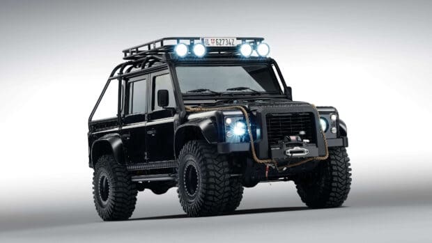 A black Land Rover Defender equipped for rugged terrain stands against a plain background, 4K Desktop Wallpaper