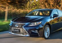 A black Lexus Es is driving swiftly with trees blurred in the background, 4K Desktop Wallpaper