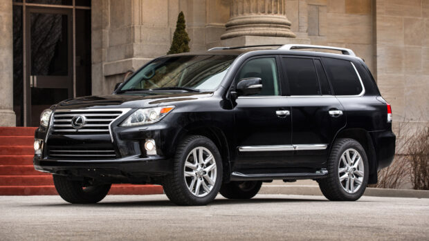 A black Lexus LX with chrome details is parked near stone columns on a street, 4K Desktop Wallpaper