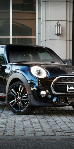 A black Mini Cooper car is parked in front of a building with windows and a light fixture, HD Phone Wallpaper
