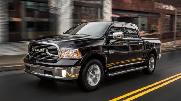 A black Ram pickup is driving on a city street with reflections on its shiny surface, 4K Desktop Wallpaper