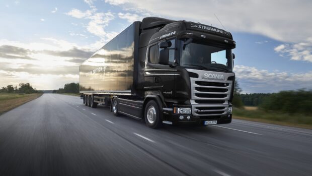 A black Scania truck is driving on a rural highway under a cloudy sky, HD Desktop Wallpaper