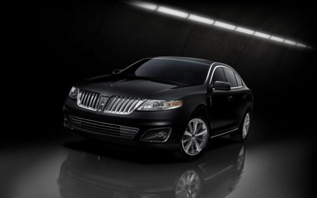 A sleek black Lincoln car shines under modern lighting in a dark tunnel setting, HD Desktop Wallpaper