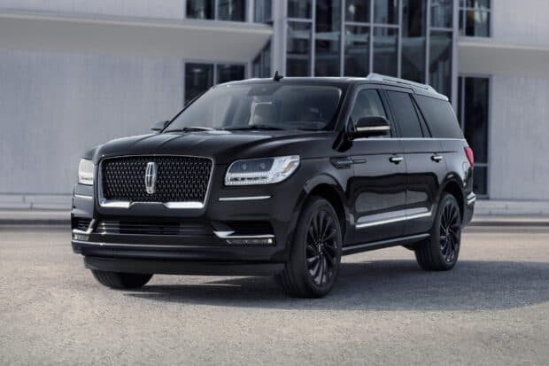 A black Lincoln car stands still outside a modern building, 2K Desktop Wallpaper