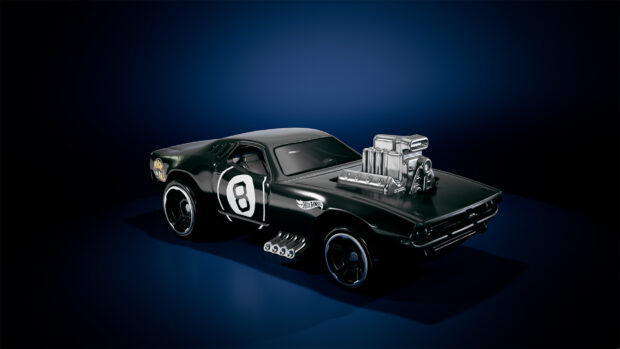 A black muscle car toy with the Hot Wheels logo and number 8 is displayed on a blue surface, HD Desktop Wallpaper