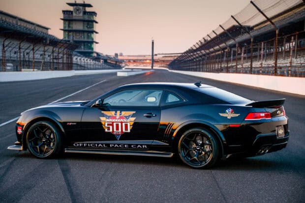 A black pace car with Indianapolis Motor Speedway logos is parked on the raceway during sunset, 2K Desktop Wallpaper
