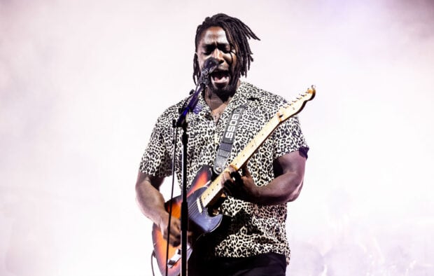 A Bloc Party Band guitarist passionately playing guitar and singing on stage, HD Desktop Wallpaper
