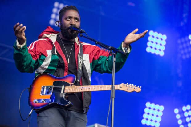 A band member of Bloc Party plays guitar passionately during a concert, HD Desktop Wallpaper