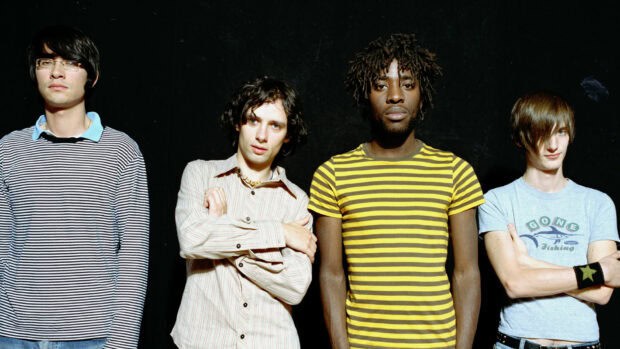 The Bloc Party band stands in front of a black background with serious expressions, HD Desktop Wallpaper