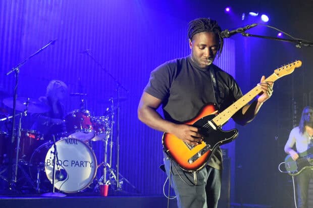 A guitarist plays intensely during Bloc Party band performance at a concert, HD Desktop Wallpaper