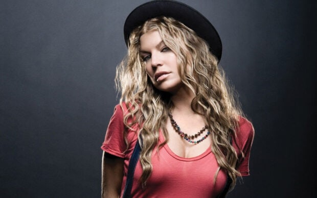 A blonde woman with curly hair wearing a hat and red top poses with a serious expression in The Black Eyed Peas, HD Desktop Wallpaper