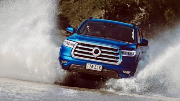 A blue Great Wall Motors vehicle splashing through water on a rugged terrain, HD Desktop Wallpaper