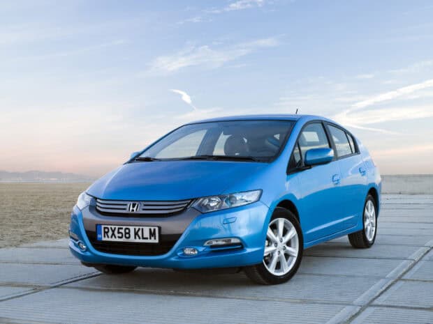 Blue Honda Insight car is parked near the sea with a clear sky in the background, 2K Desktop Wallpaper