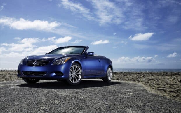 A blue Infiniti G37 parked by the beach under a bright sky with clouds, HD Desktop Wallpaper