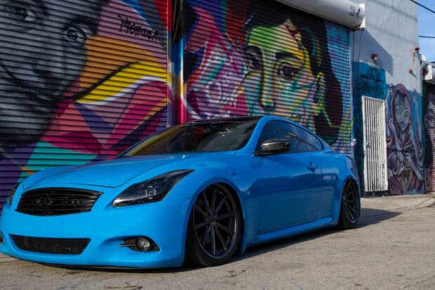 A sleek Infiniti G37 is captured in front of a colorful graffiti wall in the city, HD Desktop Wallpaper