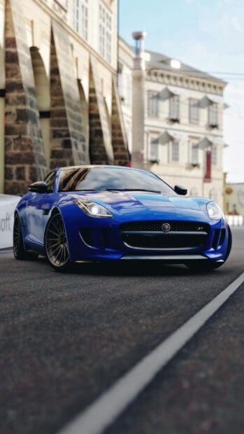 A blue Jaguar F Type is parked near an old stone building under daylight, HD Phone Wallpaper