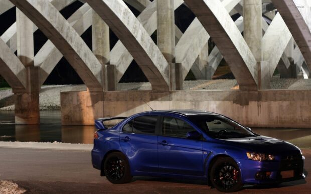 A blue Lancer Evo is parked on the road under large concrete bridge arches at night, HD Desktop Wallpaper