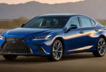 A blue Lexus ES is parked on a desert road with mountains in the background at sunset, HD Desktop Wallpaper