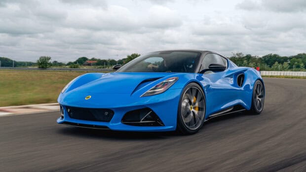 A blue Lotus Emira is driving fast on a curved race track on a cloudy day, 2K Desktop Wallpaper