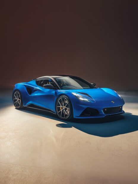 The blue Lotus Emira sports car is shown in a studio with soft lighting, 2K Mobile Wallpaper