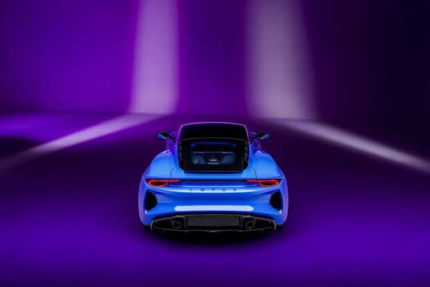 A blue Lotus Emira is shown from the rear in a studio with purple lighting, 2K Desktop Wallpaper
