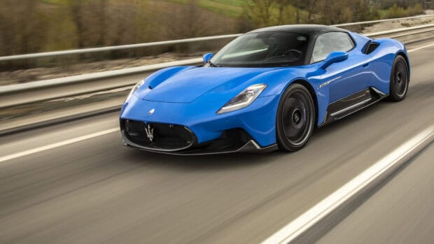 A blue Maserati MC20 speeding on a highway with blurred surroundings, HD Desktop Wallpaper