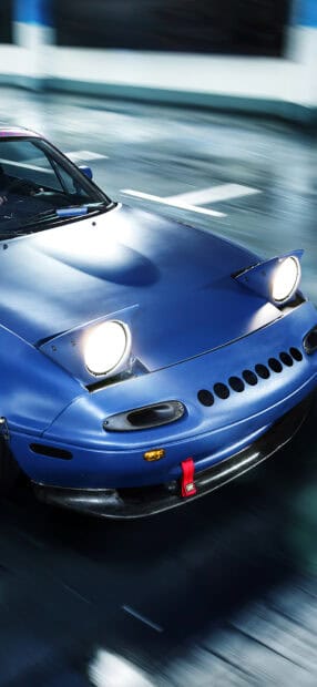 A blue Mazda MX 5 Miata is captured speeding on a road with headlights on, HD Phone Wallpaper