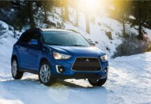 A blue Mitsubishi Outlander drives through a sunny snowy forest road, HD Desktop Wallpaper