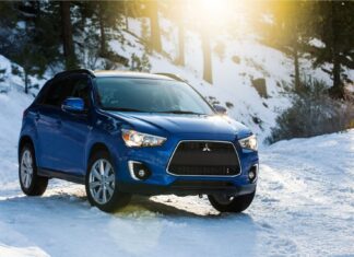 A blue Mitsubishi Outlander drives through a sunny snowy forest road, HD Desktop Wallpaper