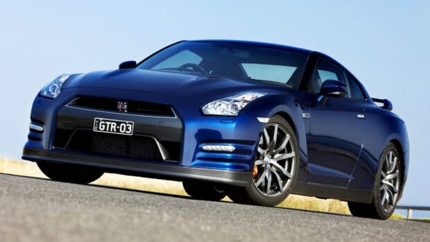 A blue Nissan GT R is parked on the road with a clear sky in the background, HD Desktop Wallpaper