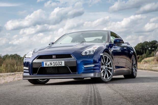 A blue Nissan GT R parked on a rural road under a cloudy sky, 2K Desktop Wallpaper